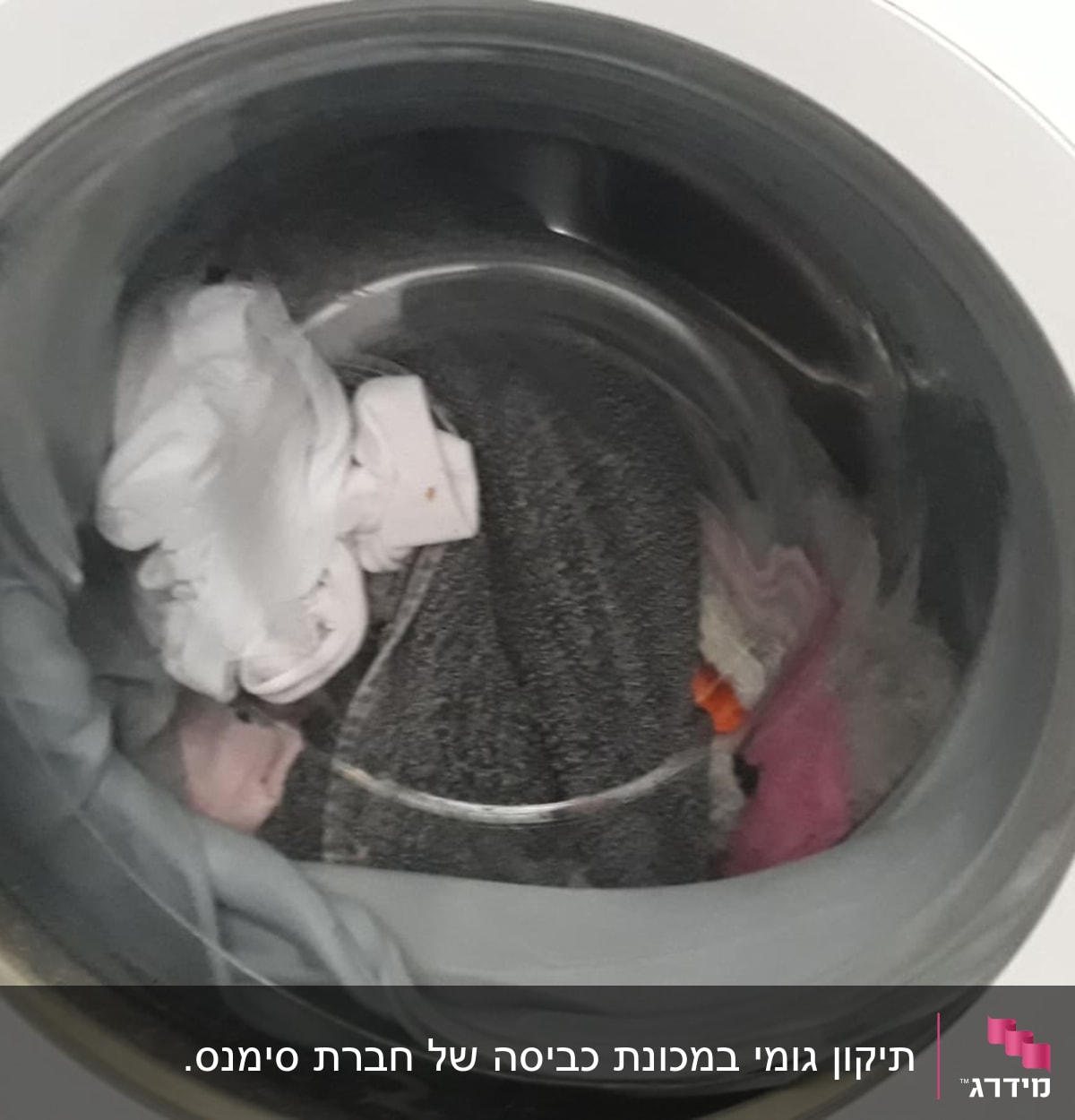 מכונת כביסה עם בגדים בתוף הכביסה